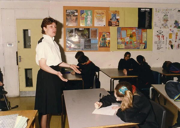 Woman police officer talking in a school classroom