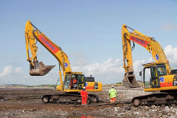 Construction workers working on the foreshore of the Solway Firth near Workington, installing the power cable that will carry the electricity from the new Robin Rigg offshore wind farm in the Solway Firth. Robin Rigg is one of the largest wind