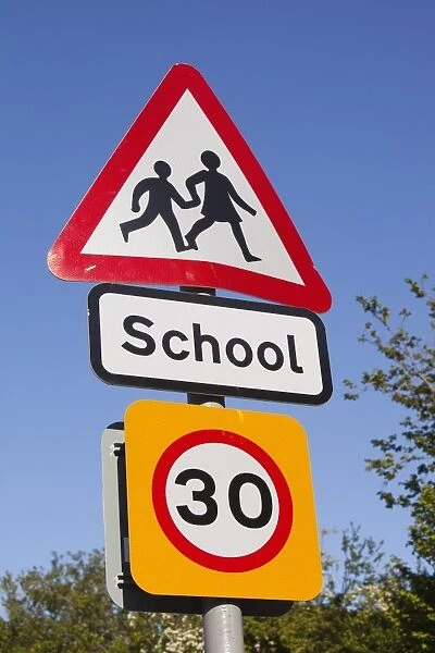 A school sign and speed limit sign in Berrynarbor, Devon, UK