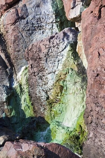 Sea Cliffs stained green from copper deposits leaching from the old Geevor Tin Mine near St Just in Cornwall