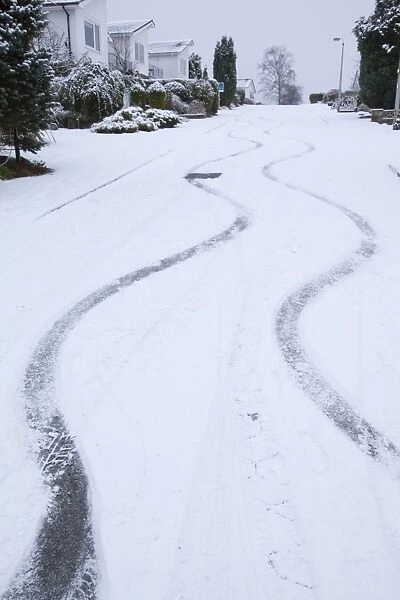 Skid marks in the snow from a car on a steep road in Ambleside UK