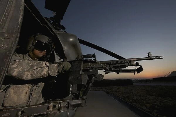 A UH-60L Blackhawk door gunner mans a M-240G machine gun