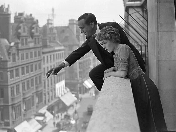Actor Douglas Fairbanks seen here with his wife throwing roses from the balcony of