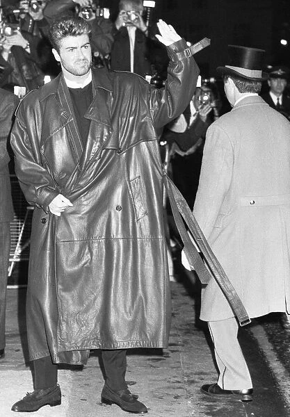 George Michael waves to fans outside the Savoy Hotel, where the launch party for his