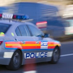 A police car speeding through the streets of London