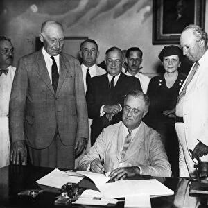 President Franklin D. Roosevelt signing the Social Security Act in the Cabinet Room of the White House, 14 August 1935. Behind him, Congress members, left to right: Robert Doughton; Robert Wagner; John Dingell, Sr. ; Secretary of Labor Frances Perkins; Pat Harrison; and David J. Lewis