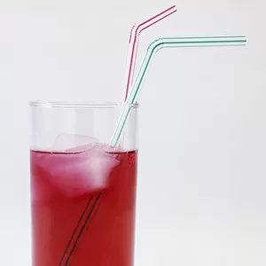 Glass of Raspberry cordial with ice and two straws