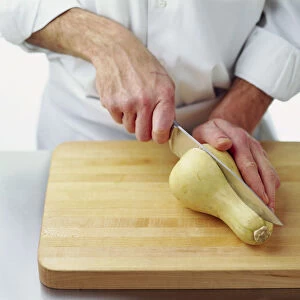 Man cutting a butternut squash in half lengthways