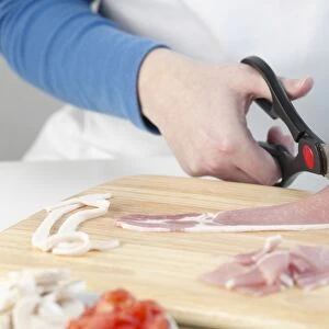 Person cutting bacon with scissors
