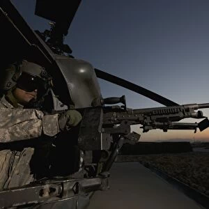 A UH-60L Blackhawk door gunner mans a M-240G machine gun
