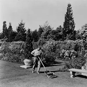 Gardener pushing lawn mower, posed to illustrate Rudyard Kipling's poem The Glory of the Garden, 1917 Creator: Frances Benjamin Johnston